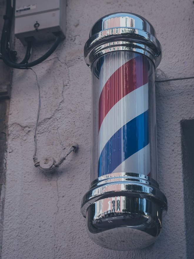 A traditional barber's pole on the frontage at Millburn Wynd