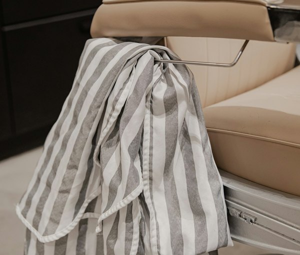 A striped cape over the barber's chair between shaves